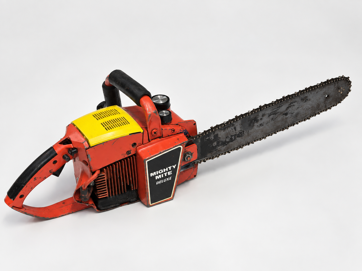 Vintage Mighty Mite Deluxe 34cc chainsaw on clean studio background