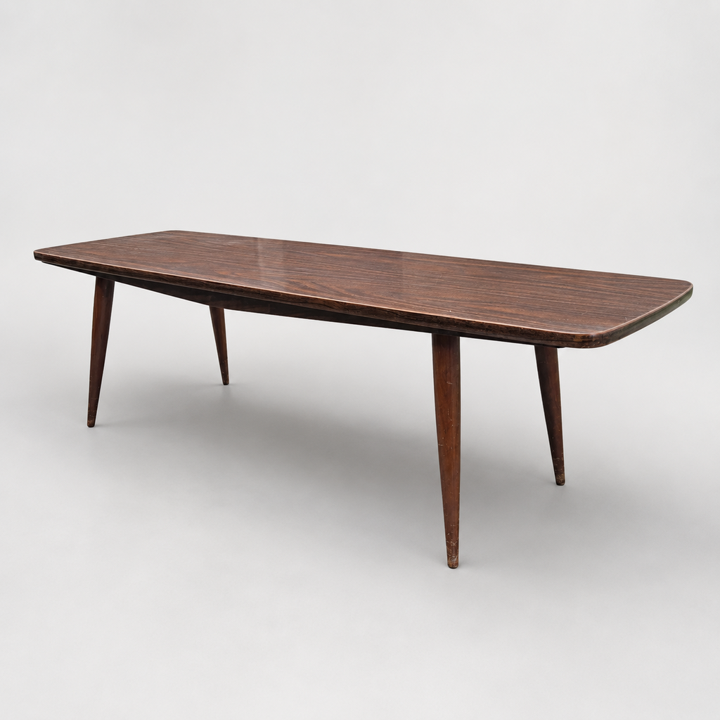 Underside of vintage mid-century coffee table showing tapered legs and atomic starburst graphics